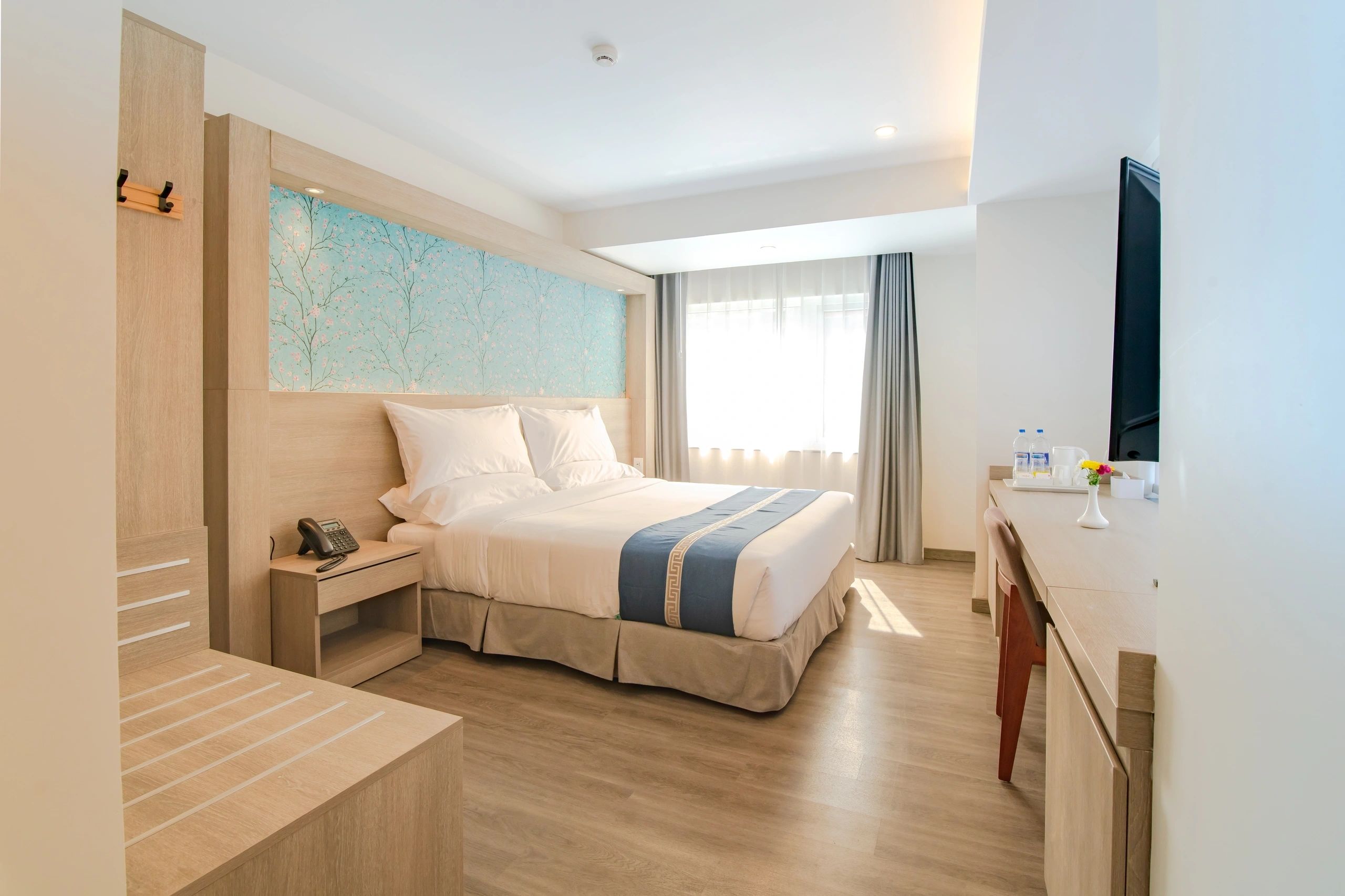 Deluxe King Room featuring Luxury King Bed, Warm Hardwood Flooring, and Ambient Lighting